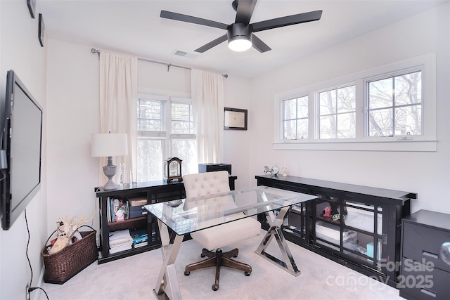 office featuring carpet, plenty of natural light, visible vents, and a ceiling fan