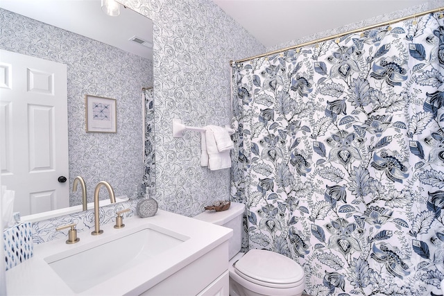 full bathroom with visible vents, vanity, toilet, and wallpapered walls