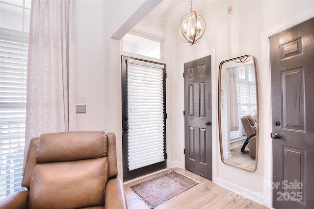 entrance foyer featuring light wood-style flooring and a chandelier