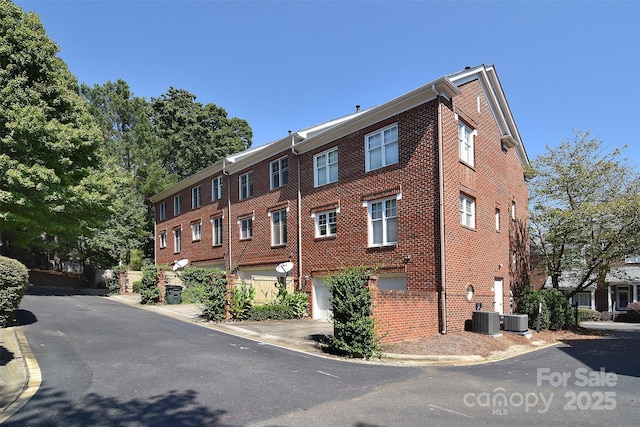 view of property featuring an attached garage and cooling unit