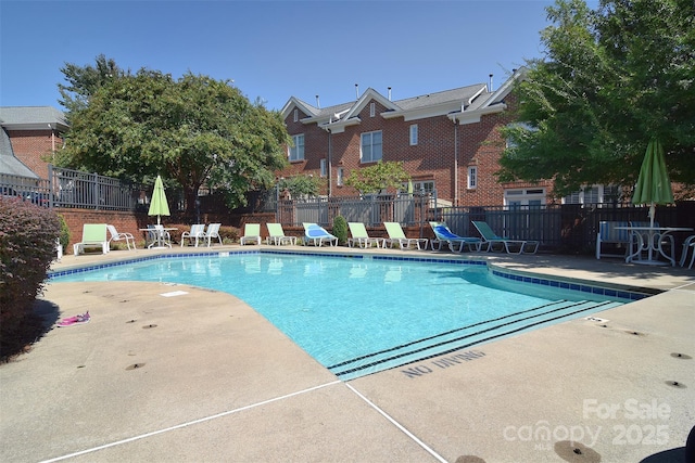 community pool featuring a patio area and fence