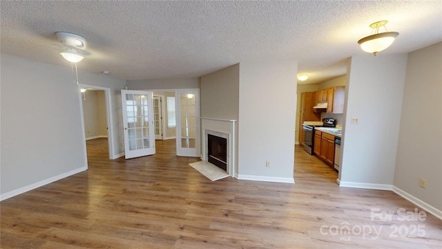 unfurnished living room with a premium fireplace, light wood-type flooring, and baseboards