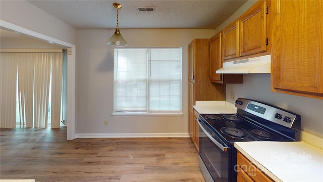 kitchen featuring brown cabinetry, stainless steel range with electric stovetop, light countertops, a textured ceiling, and under cabinet range hood