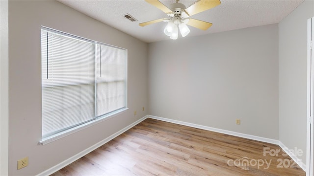 unfurnished room featuring a ceiling fan, baseboards, visible vents, and a textured ceiling