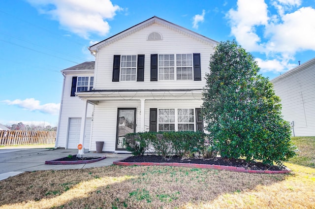 traditional-style home with aphalt driveway, covered porch, a garage, fence, and a front lawn