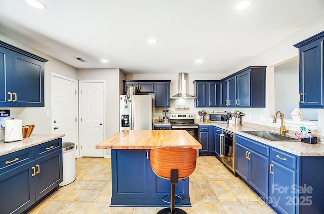 kitchen with visible vents, wine cooler, stainless steel appliances, wall chimney range hood, and a sink