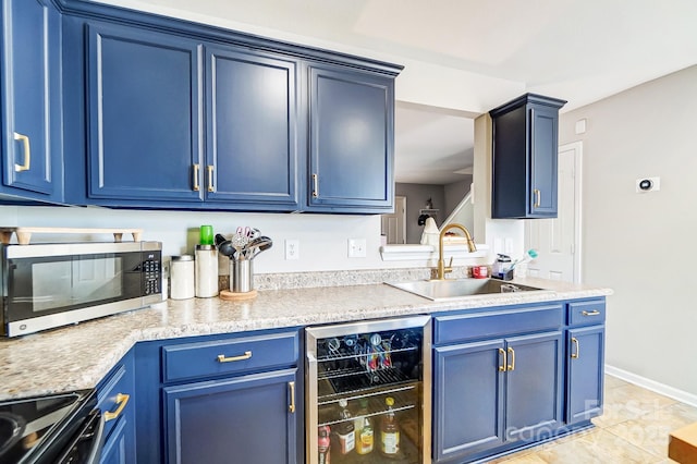 kitchen with blue cabinets, wine cooler, stainless steel microwave, and a sink