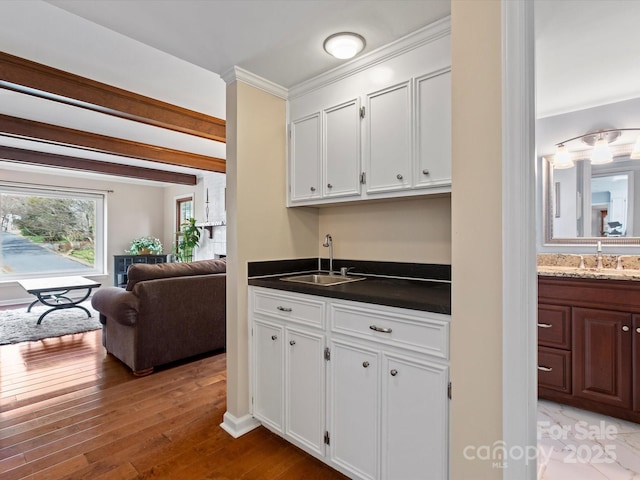 kitchen featuring a sink, light wood finished floors, and white cabinetry