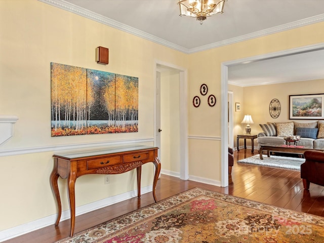 interior space with a notable chandelier, crown molding, baseboards, and hardwood / wood-style flooring