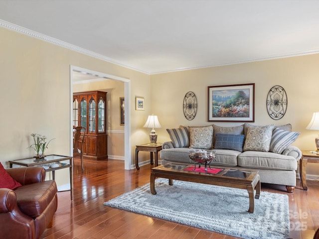 living room featuring baseboards, wood-type flooring, and ornamental molding