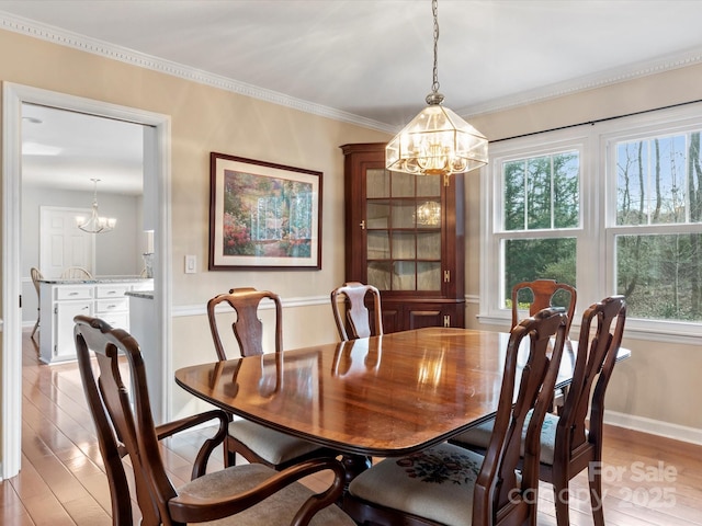 dining area featuring a notable chandelier, light wood-style floors, and plenty of natural light