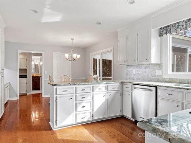 kitchen featuring stainless steel dishwasher, a peninsula, and white cabinets