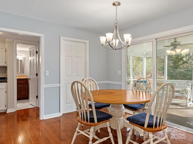 dining room with baseboards, dark wood-style flooring, and ceiling fan with notable chandelier