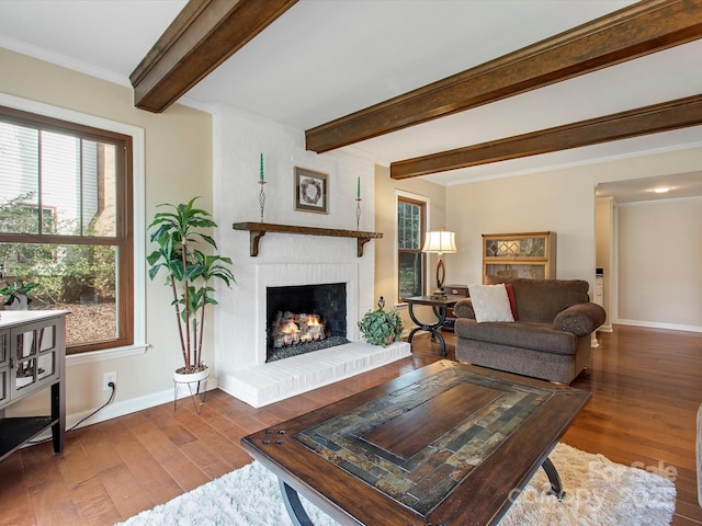 living area with beam ceiling, a fireplace, baseboards, and hardwood / wood-style floors