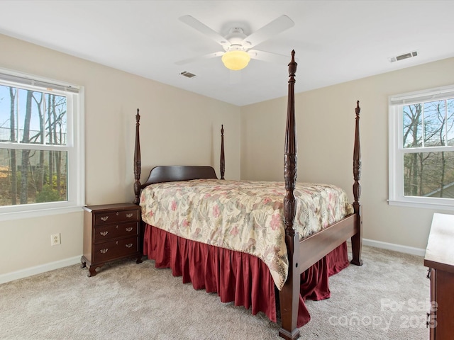 bedroom with multiple windows, visible vents, and light carpet