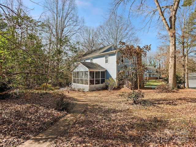 rear view of house featuring a chimney and a sunroom