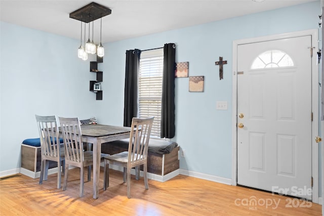 dining area with light wood-type flooring, visible vents, and baseboards