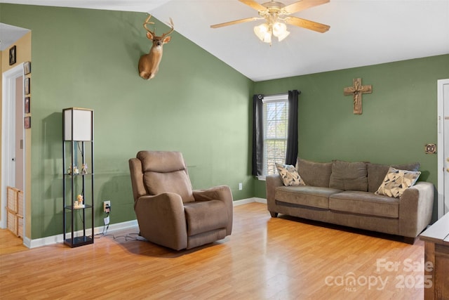 living area featuring lofted ceiling, ceiling fan, baseboards, and wood finished floors