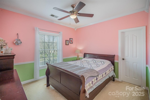 carpeted bedroom featuring baseboards, visible vents, a ceiling fan, and ornamental molding