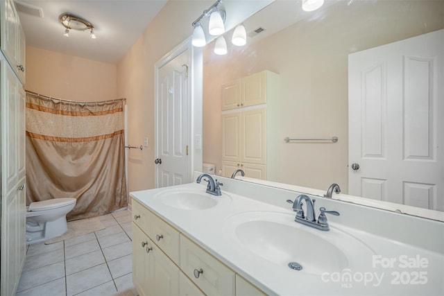 bathroom with toilet, visible vents, a sink, and tile patterned floors