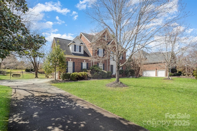 view of front of property with a garage, a front yard, concrete driveway, and brick siding