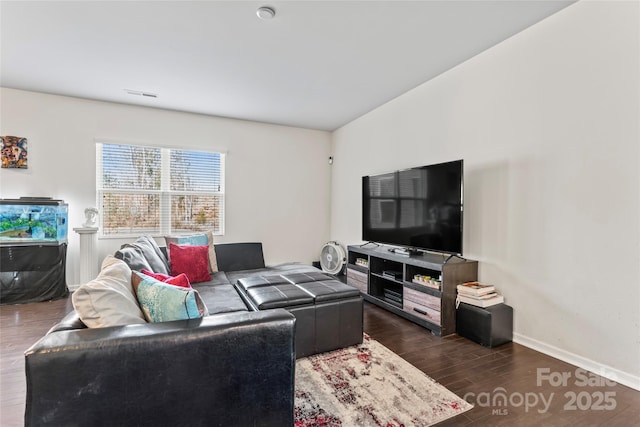 living area featuring dark wood-type flooring, visible vents, and baseboards