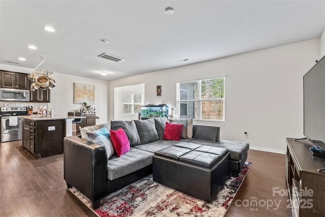 living area with visible vents, baseboards, dark wood-style flooring, and recessed lighting