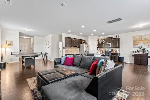 living room with dark wood-style floors, recessed lighting, visible vents, and baseboards