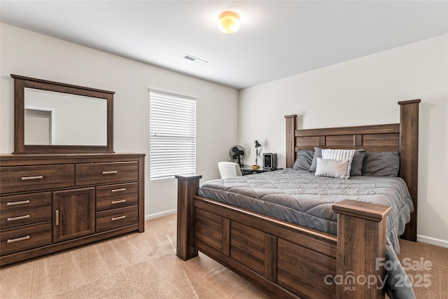 bedroom featuring visible vents, light carpet, and baseboards