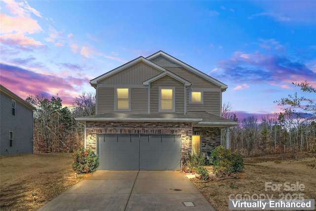 traditional-style home with an attached garage, stone siding, and concrete driveway