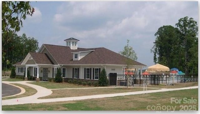 view of front facade with a front lawn and fence