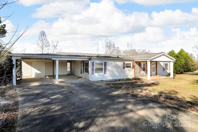 single story home featuring covered porch, concrete driveway, and a carport