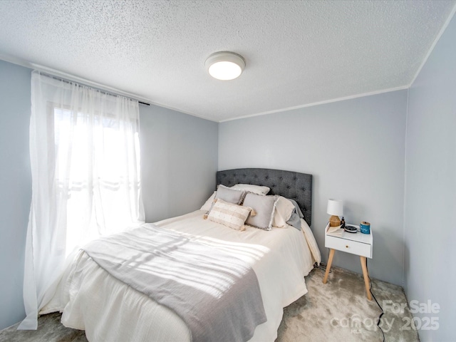 bedroom with a textured ceiling, carpet floors, and ornamental molding