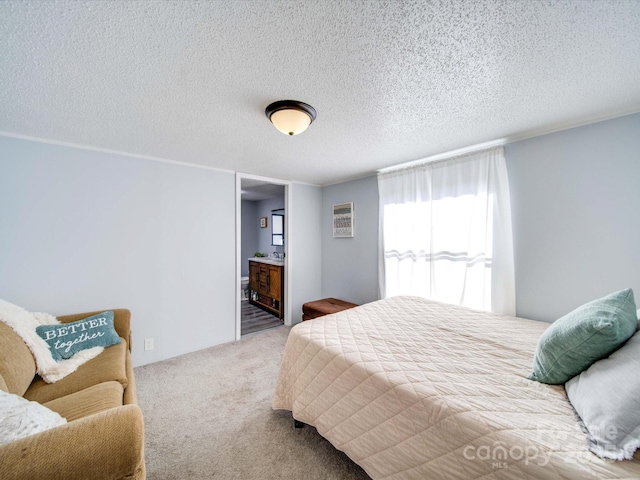 carpeted bedroom with connected bathroom and a textured ceiling