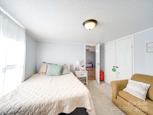 bedroom featuring a closet, light colored carpet, and a textured ceiling