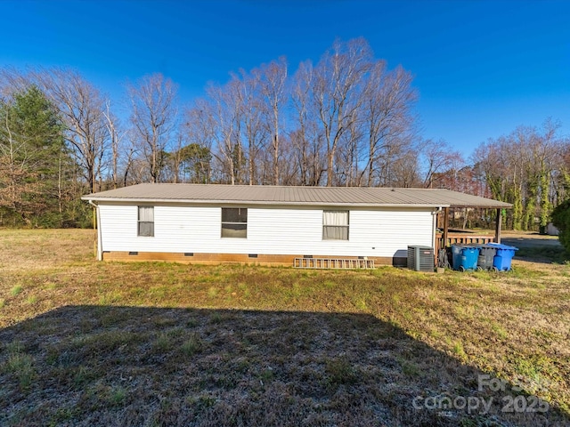 back of house featuring a yard, metal roof, and crawl space