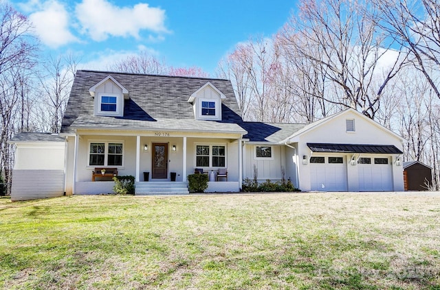 cape cod house with a porch, board and batten siding, an attached garage, and a front lawn