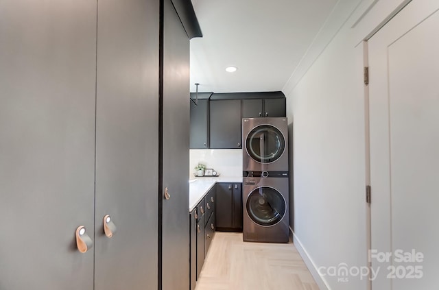 laundry area featuring stacked washer and dryer, ornamental molding, recessed lighting, cabinet space, and baseboards