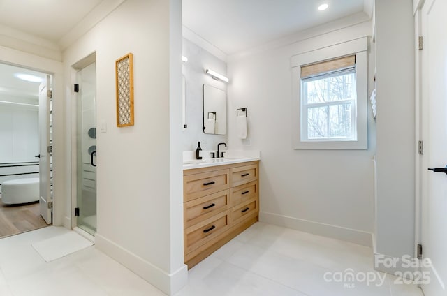 bathroom featuring a stall shower, vanity, baseboards, and ornamental molding