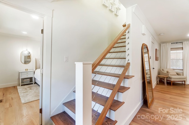 stairway with wood finished floors and baseboards