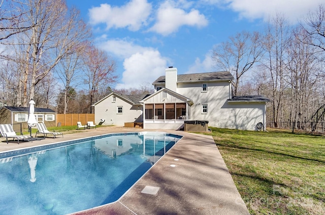 view of swimming pool featuring fence, a fenced in pool, a sunroom, a hot tub, and an outdoor structure