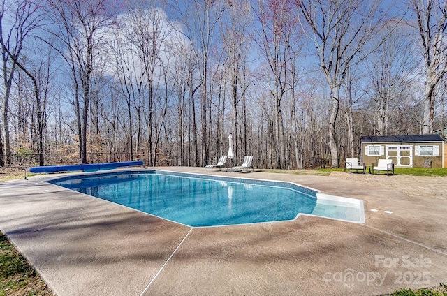 view of swimming pool with a storage structure, a covered pool, a patio, and an outdoor structure