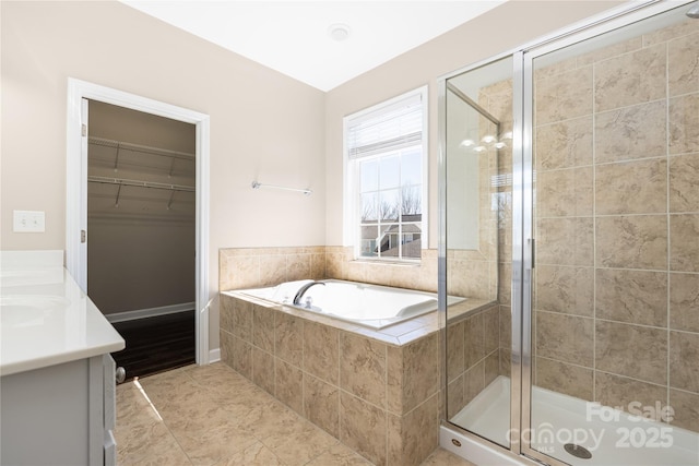 full bath featuring a garden tub, a shower stall, a spacious closet, and vanity