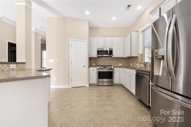 kitchen featuring stainless steel appliances, white cabinets, visible vents, and a sink