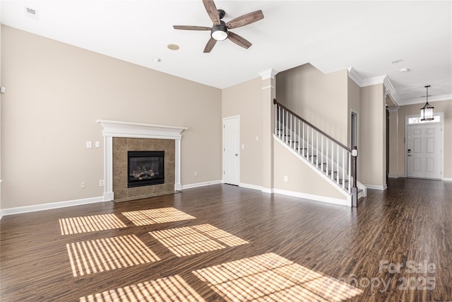 unfurnished living room with stairway, wood finished floors, visible vents, and baseboards