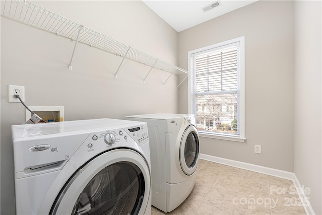 washroom with laundry area, baseboards, visible vents, and washing machine and clothes dryer