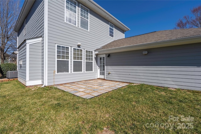 rear view of house featuring a patio area, a yard, and central AC