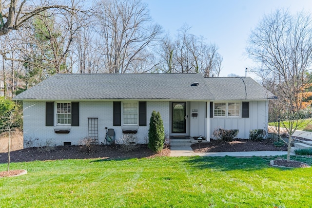 single story home with board and batten siding, a front yard, and brick siding