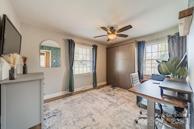 office area featuring a ceiling fan, baseboards, a wealth of natural light, and wood finished floors