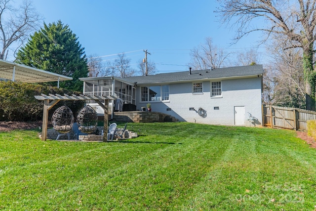 rear view of house with brick siding, fence, a sunroom, crawl space, and a lawn